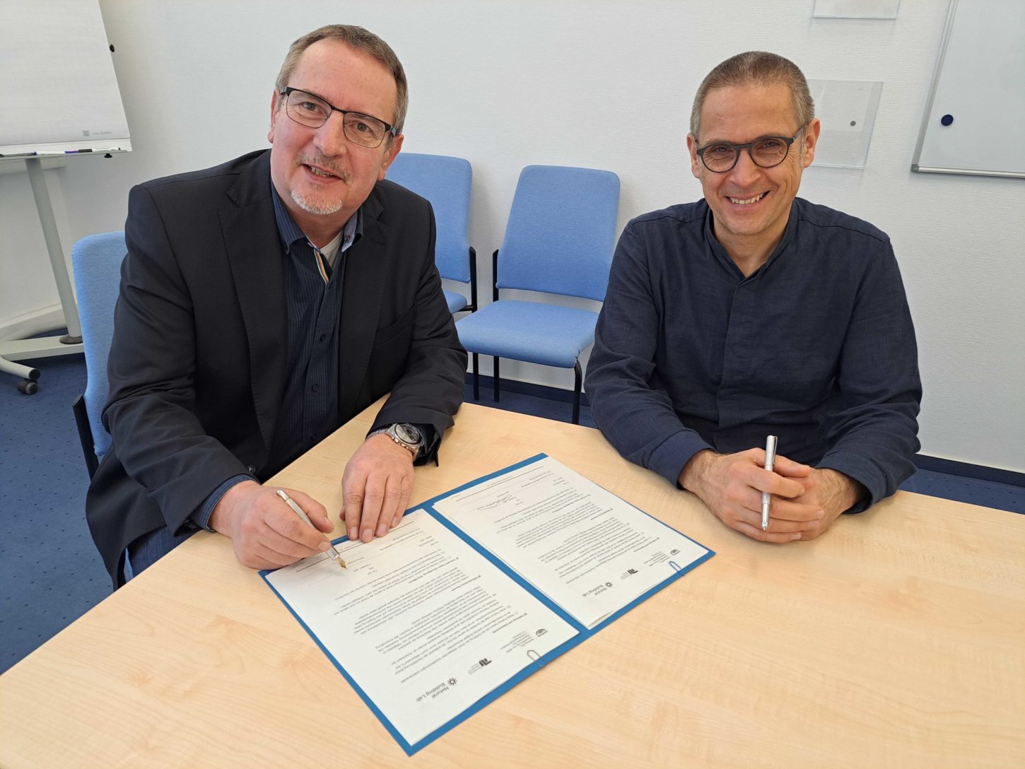 Werkleiter Bernd Richter und Prof. Eike Roswag-Klinge unterschreiben die Kooperationsvereinbarung
